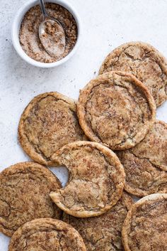 a pile of cookies sitting on top of a table next to a bowl of peanut butter