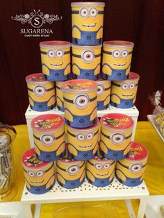 a bunch of yellow and blue minion birthday cakes on a table with some decorations