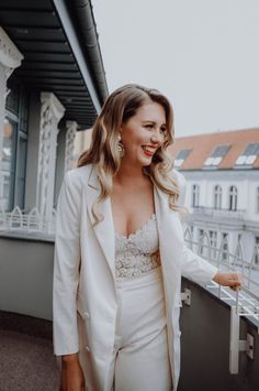 a woman standing on top of a balcony next to a building