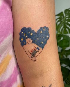 a woman's arm with a tattoo on it that has a heart and stars