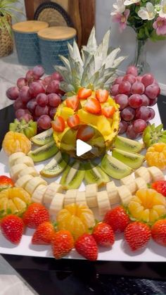 a fruit platter with bananas, strawberries, grapes and pineapples