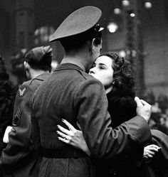 black and white photograph of a man kissing a woman