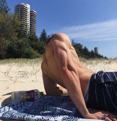 a man laying on top of a towel on the beach