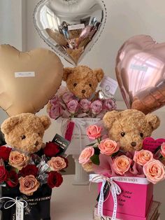 three teddy bears sitting next to each other in front of heart shaped balloons and flowers