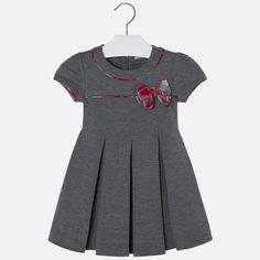 This pleated grey dress features a plaid bow and plaid piping detail. Baby Frock Designs, Frock Designs, African Dresses For Kids, Baby Frock, Kids Dress Patterns