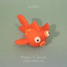 a close up of a toy fish on a green surface with the words collidish above it