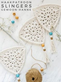 two crocheted doily with yarn and balls of thread on a marble surface