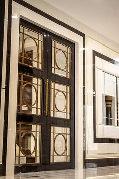 the front door to a building with decorative glass and metal panels on it's sides