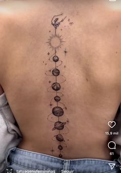 the back of a woman's upper back tattoo with planets and stars on it