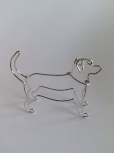 a wire sculpture of a dog on a white background