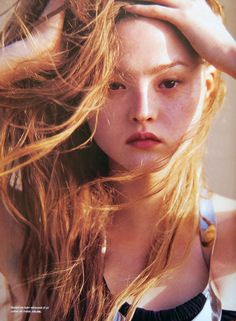 a woman with long blonde hair is posing for a magazine cover photo, holding her hand on her head