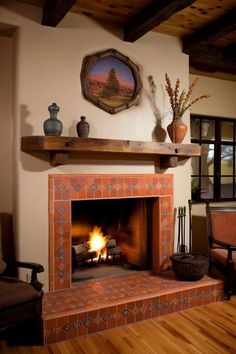 a fire place in a living room with wood flooring and tile on the fireplace