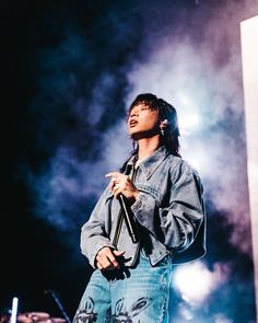 a man standing on top of a stage holding a microphone in front of his face