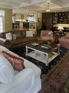 a living room with couches, chairs and tables in the middle of an open floor plan