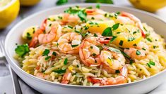 a white bowl filled with shrimp and lemon risoki salad on top of a table