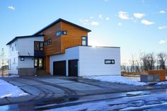 a large house with two garages on the front and side of it in the snow