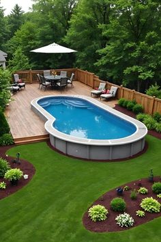 an above ground pool surrounded by lush green grass and trees with patio furniture around it