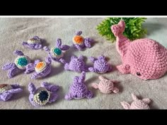 crocheted stuffed animals are laying on the ground next to each other and some plants