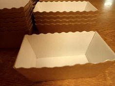 three empty boxes sitting on top of a wooden table