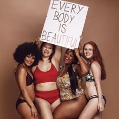 four women in bikinis holding up a sign that says every body is beautiful on it