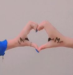 two hands making a heart shape with the word mom and dad written on their palms