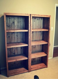 two wooden bookshelves sitting next to each other in a room with carpeted flooring