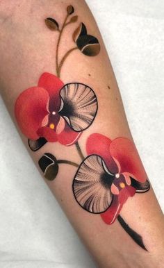 a close up of a person's arm with tattoos on it and red flowers