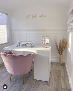 a white desk with a pink chair next to it