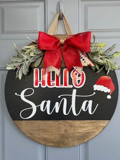 a wooden sign that says hello santa hanging on a door with a red bow around it