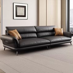 a black leather couch sitting on top of a carpeted floor next to a window