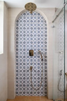 a bathroom with blue and white tiles on the shower wall