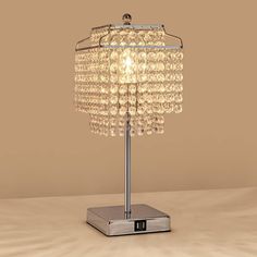 a crystal table lamp sitting on top of a wooden table