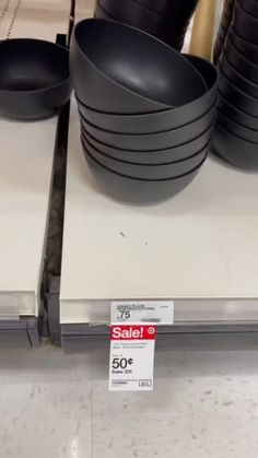 black bowls are stacked on top of each other for sale at the store's counter