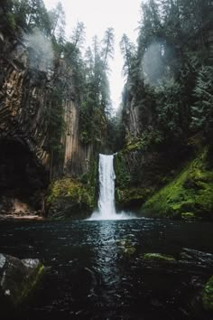 a large waterfall in the middle of a forest