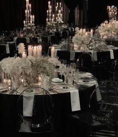 a table is set with white flowers and candles for an elegant dinner or party event