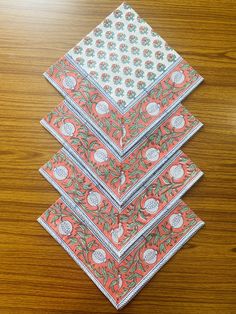 four napkins are stacked on top of each other in different colors and patterns,