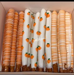 an open box filled with orange and white striped paper straws next to each other