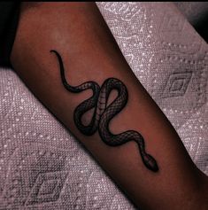 a black and white snake tattoo on the arm