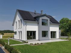 a large white house with black roof and windows