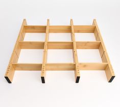 a wooden shelf with four compartments on each side and two black legs at the bottom