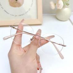 Introducing the Glimmer Rimless Glasses, the epitome of sleek, minimalist design. With their unique rimless construction, these glasses are perfect for those who love a barely-there look with a dash of sophistication. Whether you choose the elegant Black or the soft Rose Gold, these glasses add a subtle yet chic touch to any outfit. Designed with a narrow fit, the Glimmer Rimless Glasses are ideal for square, heart, oval, and oblong face shapes. The lightweight design ensures all-day comfort, making them perfect for both work and play. Features: *Rimless design for a sleek, minimalist look *Available in Black and Rose Gold for versatile styling *Narrow fit, perfect for everyday wear *Ideal for square, heart, oval, and oblong face shapes *Measurements: 49-17-145 The Glimmer Rimless Glasses Chic Glasses For Round Face, Square Face Shape Glasses, Rose Gold Glasses, Gold Glasses Frames, Stylish Reading Glasses, Frameless Glasses, Oblong Face, Glasses For Round Faces, Cute Glasses Frames