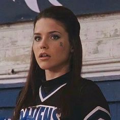 a girl with long hair wearing a cheer uniform