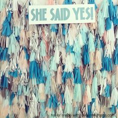 there is a sign that says she said yes in front of some tassels