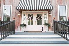 the front door of a house with black and white striped awnings on it