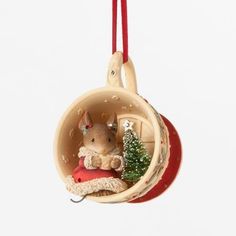 a small christmas ornament hanging from a red ribbon with a tree in it