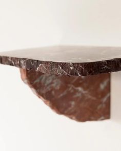 a brown marble shelf on a white wall