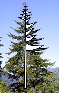 a tall metal pole with trees and mountains in the backgroung behind it