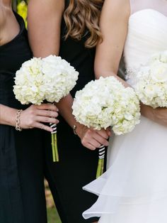 the bridesmaids are holding their bouquets with white flowers in each one's hands