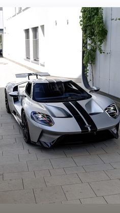 a silver and black sports car parked in front of a building