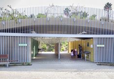 two people sitting at a table under an overpass in front of a yellow building